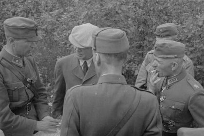 Sakspuron maantiesilta Pertjärvi Syväri_04 Kenraalimajuri Heiskanen selostaa vierailleen Pertjärven huhtikuun -42 sotatoimia_SA-kuva 15-7-1942